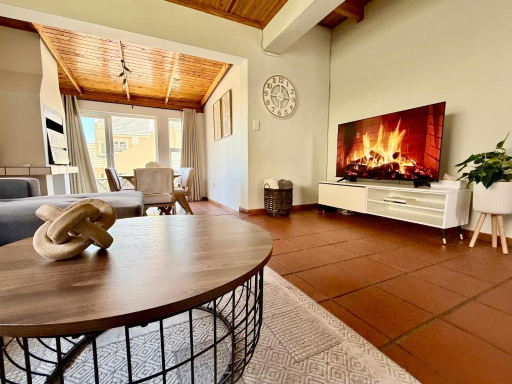 a living room with a tv and a fireplace at Bay Breeze in Eros Airport