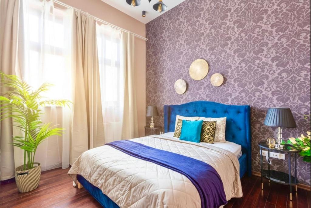 Velvet Sky Residence - InnerTown & Garage في بودابست: غرفة نوم مع سرير أزرق مع جدار أرجواني