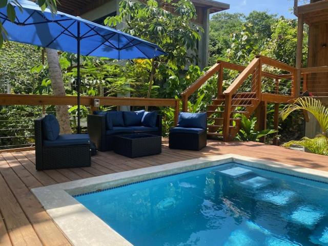a swimming pool with two chairs and an umbrella at Villa Cass in West End