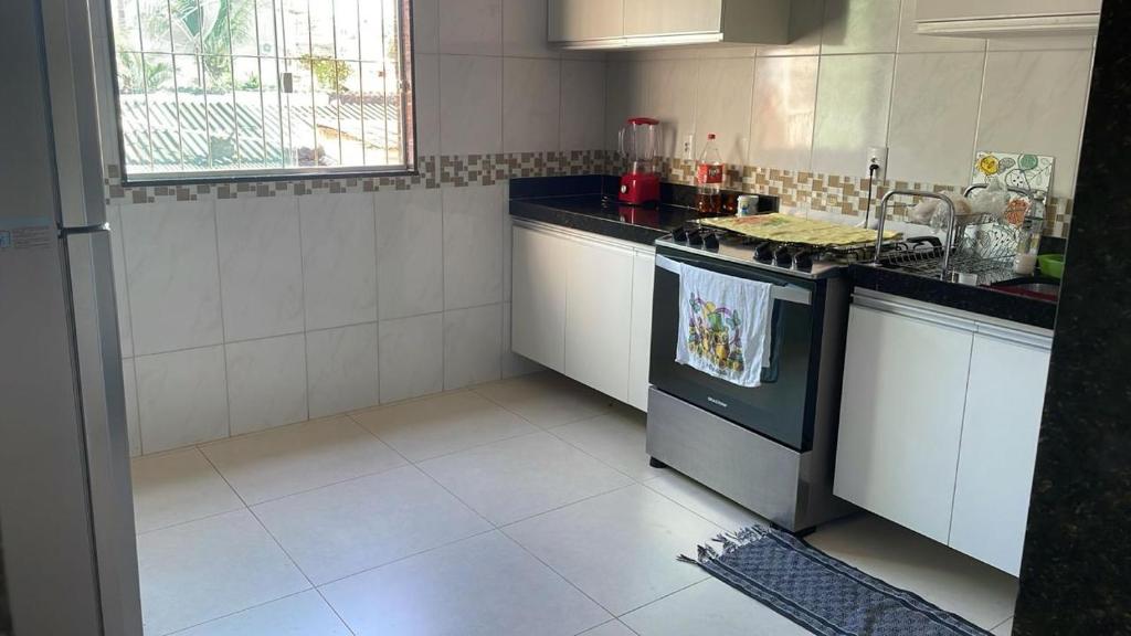 una cucina con lavello e fornello forno superiore di Casa temporada em Perocão a Guarapari