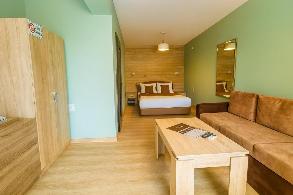 un salon avec un canapé et un lit dans l'établissement Jeweller Hotel, à Ruse