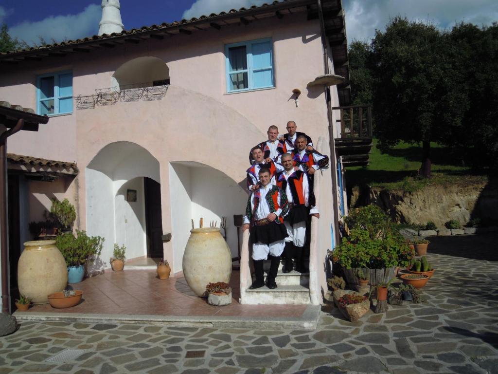 a group of people standing in front of a house at Camisadu in Oliena
