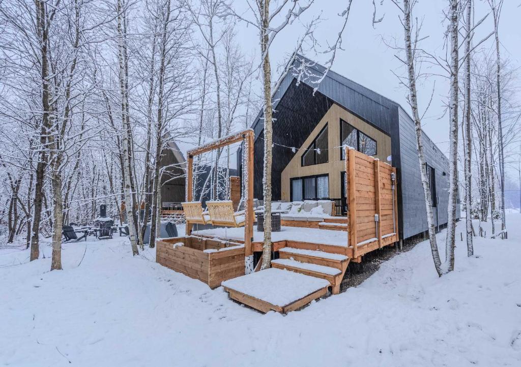 una baita di tronchi nel bosco nella neve di Kos - Domaine du Grand Portneuf - Spa Nature & Comfort a Pont-Rouge