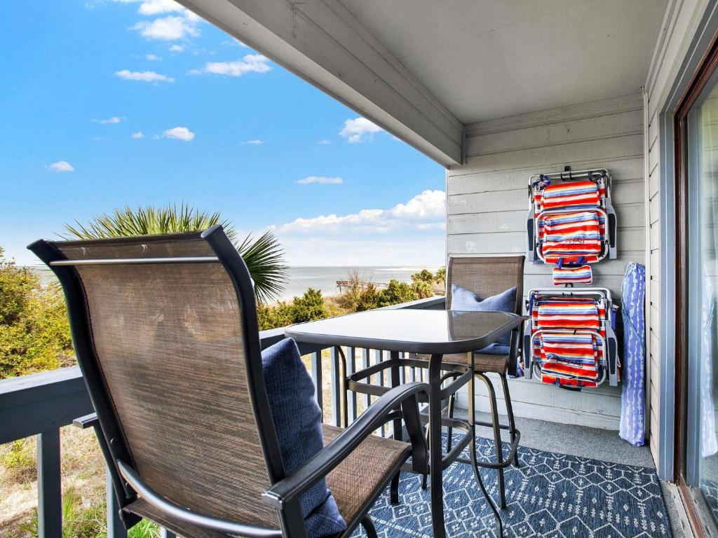 a patio with chairs and a table on a balcony at Oceanview Bliss in Tybee Island