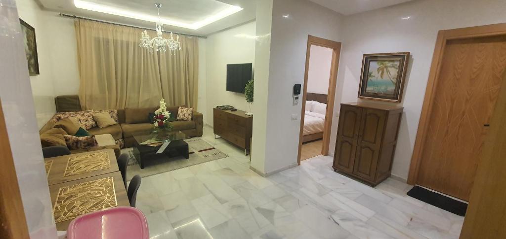 Una sala de estar con un sofá y una habitación con una cama. en Aerostay Jamal, en Dah Hammou Ben Cheïkh