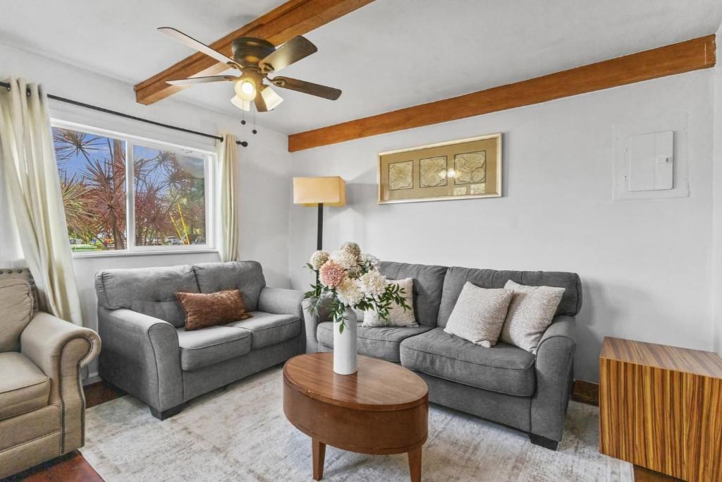 a living room with two couches and a ceiling fan at Hale Kulamanu in Hauula
