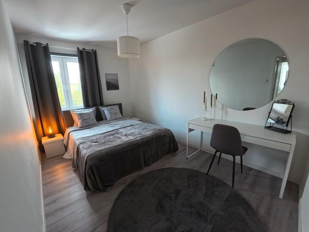 a bedroom with a bed and a desk and a mirror at Whole 3-room apartment, 10 min from malmo C & 2 min from shops in Malmö