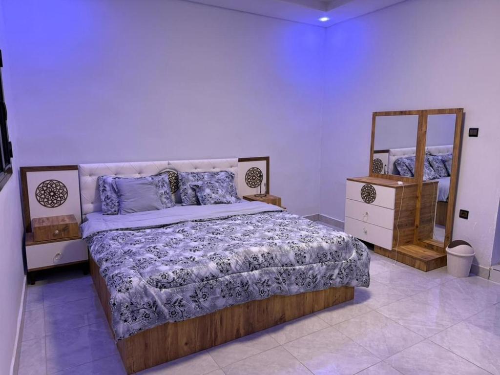 a bedroom with a large bed and a mirror at Modern Stay in Nouakchott