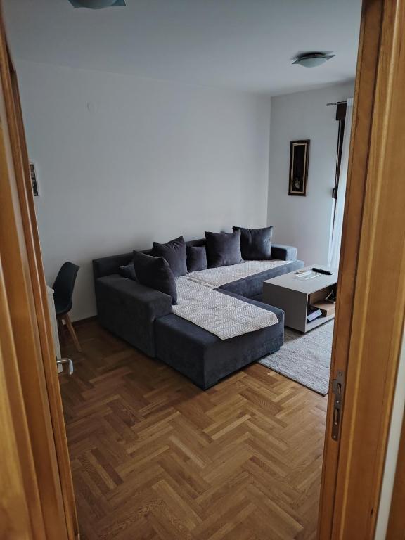 a living room with a black couch in a room at Sicilija apartment in Podgorica