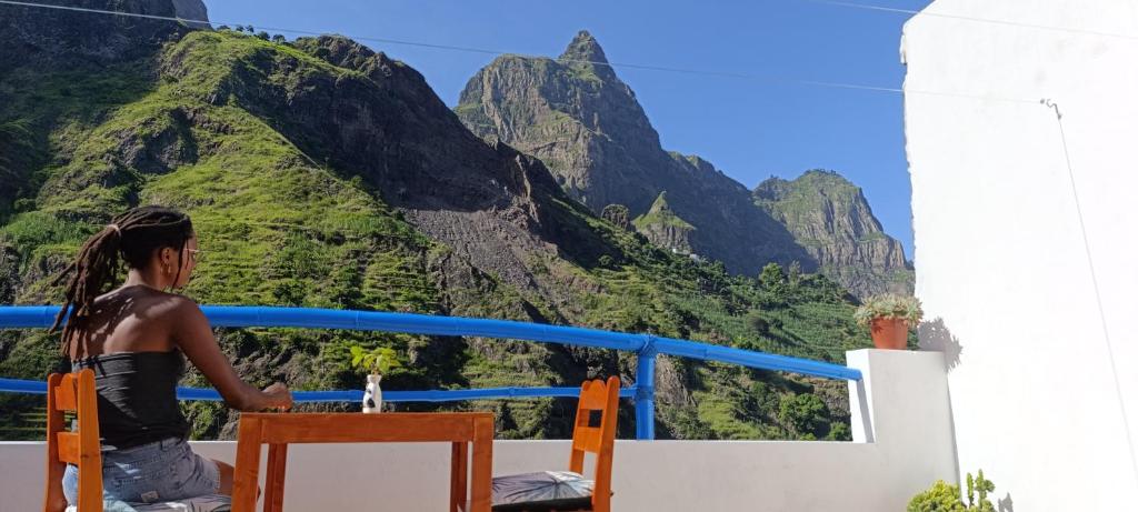 Una mujer parada en un balcón con vistas a las montañas en Oiá Paúl, en Paul