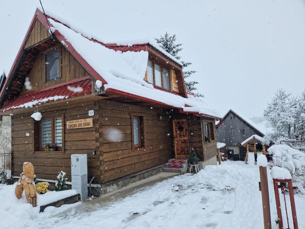 a log cabin with snow on the roof at Chalupa nad sadom in Liptovská Kokava