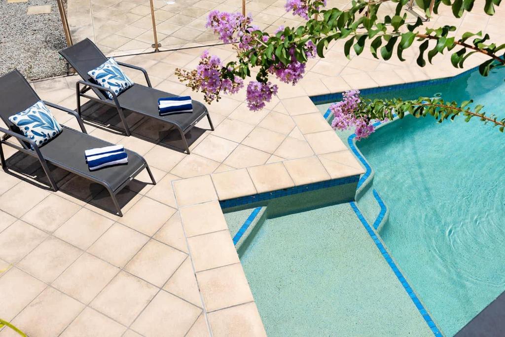- une vue de tête sur deux chaises et une piscine dans l'établissement Pet Friendly Family Home In Brisbane - Relocations and Family Stays - Fast Internet - Parking - Netflix, à Brisbane