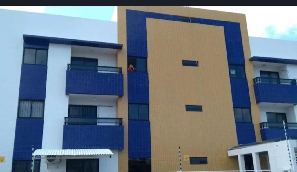 wysoki budynek z niebieskimi balkonami na boku w obiekcie Apê da Rê w mieście João Pessoa