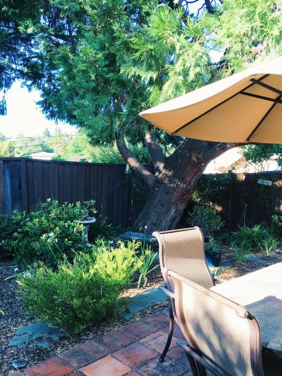 a table and two chairs and an umbrella in a yard at Super Comfortable in San Carlos