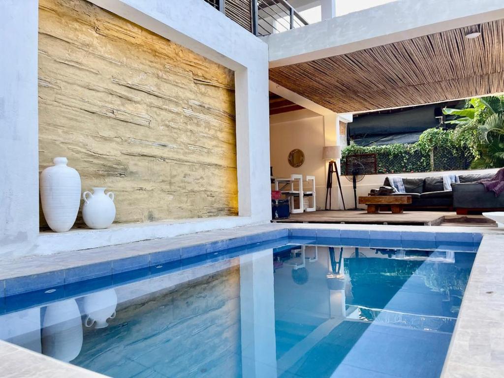 una piscina con jarrones al lado de una casa en Casa Kai, en Palomino