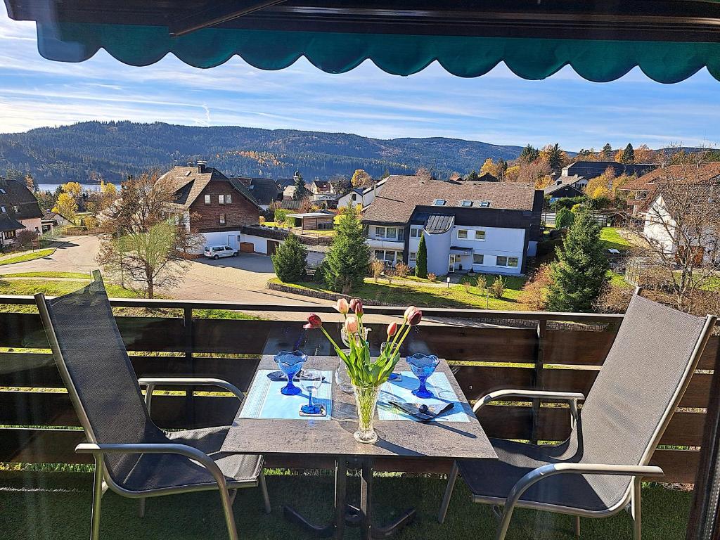 a table with a vase of flowers on a balcony at Haus Schluchseeblick in Schluchsee
