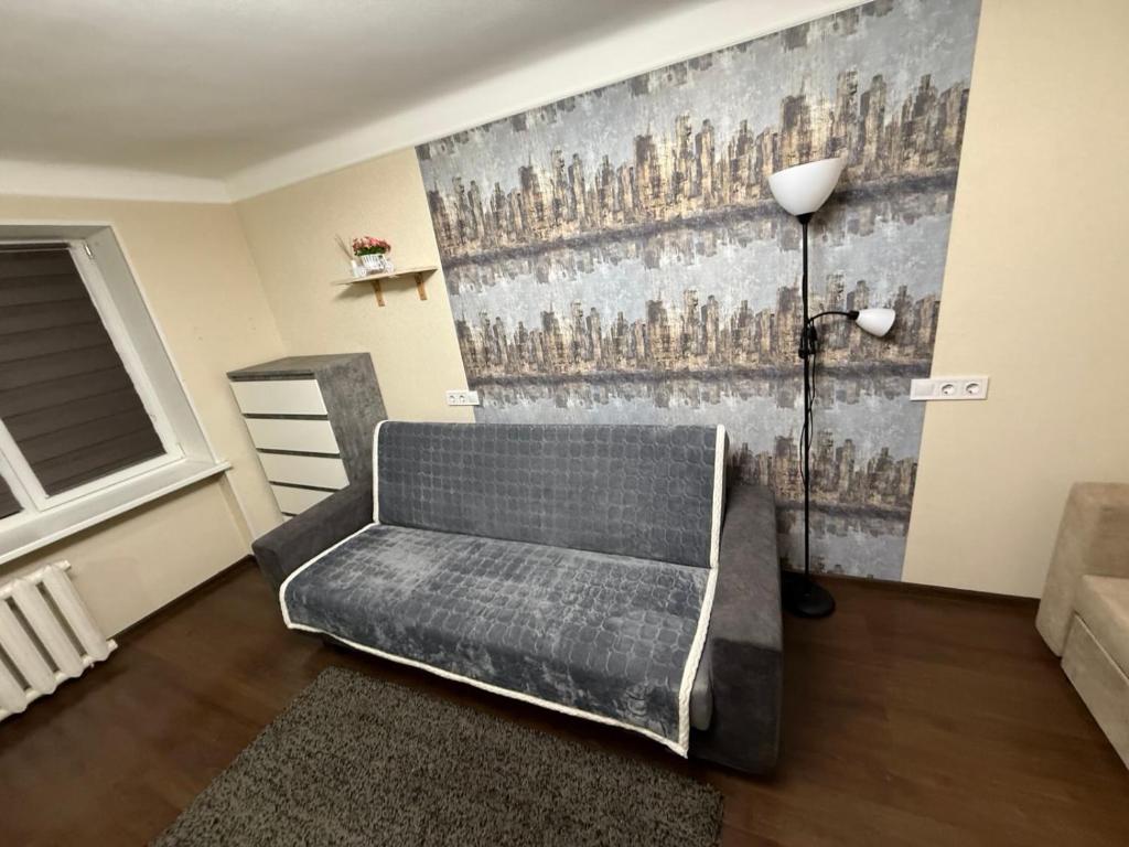 ein Wohnzimmer mit einer Couch und einem Gemälde an der Wand in der Unterkunft Alans Place to visit in Daugavpils