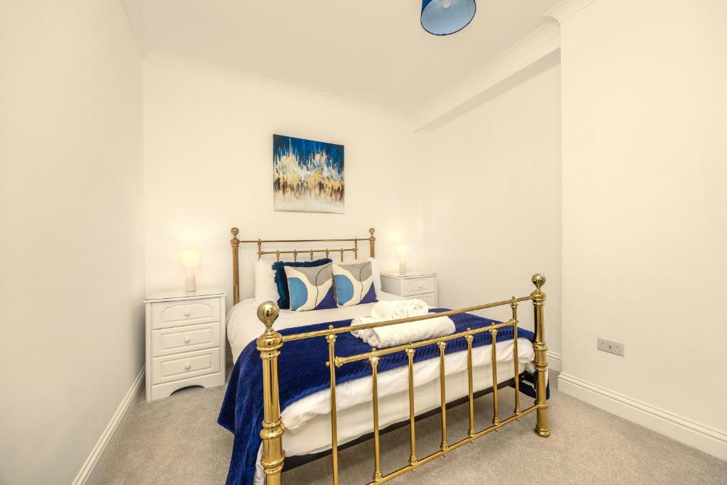a bedroom with a bed with blue and white pillows at Spacious 2 Bed & 1 Bath - Close to Beach & City Centre in Brighton & Hove