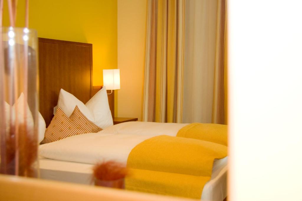 um quarto de hotel com uma cama e um espelho em Weichandhof em Munique