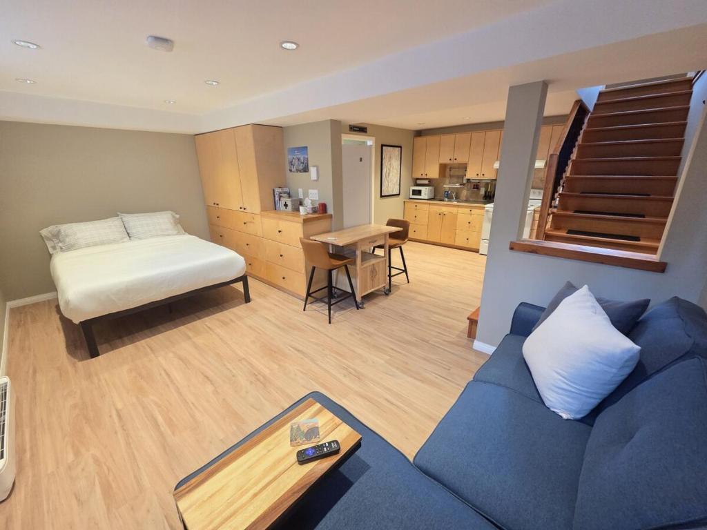 - un salon avec un canapé bleu et un lit dans l'établissement NEW Midtown Rossland Studio Apartment, à Rossland