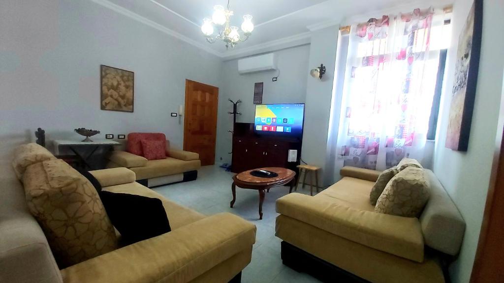 Una sala de estar con dos sofás y un televisor. en Central Apartments Shoshi, en Tirana