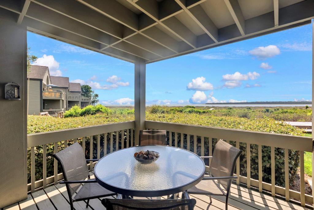 un patio con tavolo e sedie su un balcone di PW1357: 1357 Pelican Watch a Seabrook Island