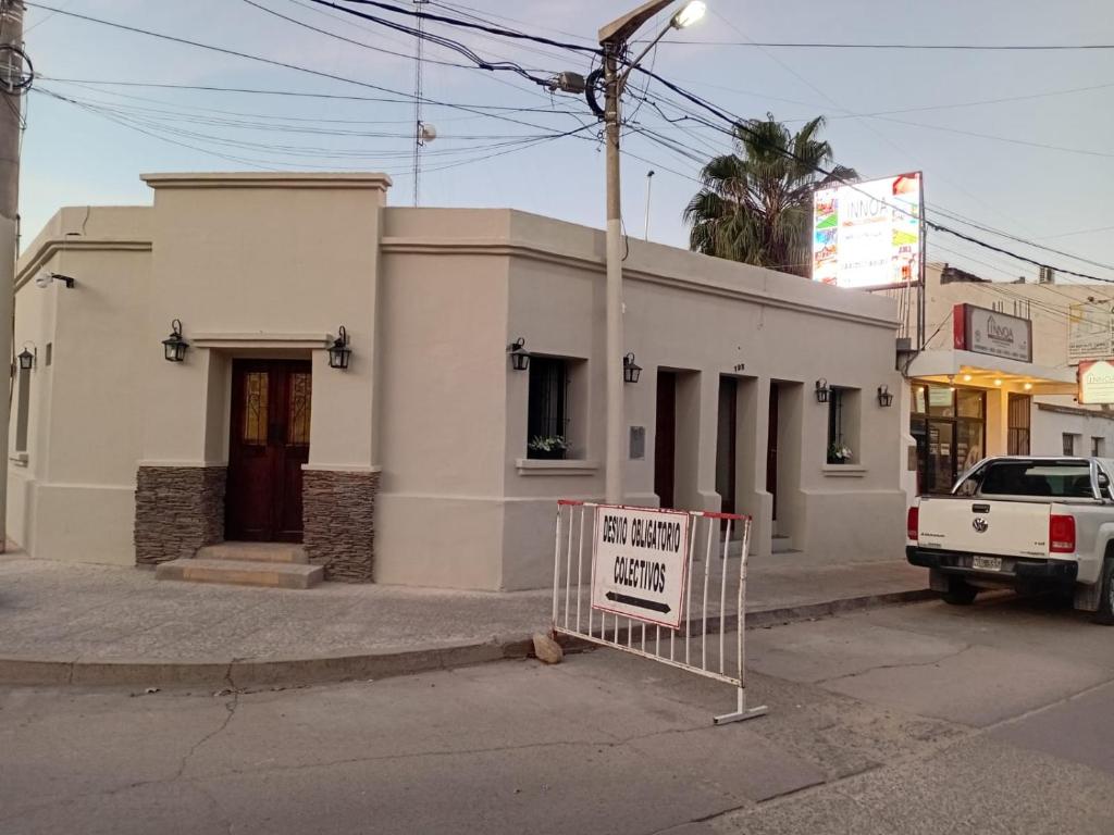 Un edificio blanco con un cartel delante. en Cafayate suite, en Cafayate
