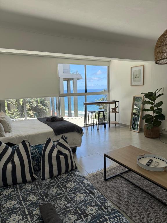 una sala de estar con una cama y una mesa en Unit 124 Camarque , Umdloti, en Umdloti