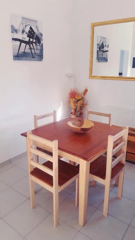 a wooden table with two chairs and a plate on it at Stukkie Cottage in Hermanus