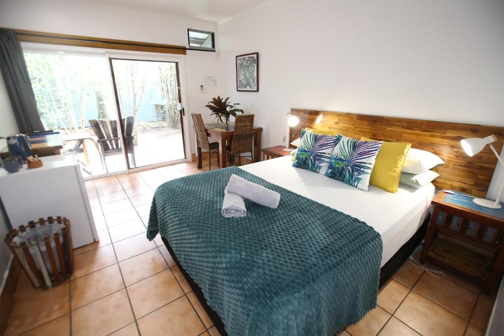 a bedroom with a bed with towels on it at Rainforest Motel, Mission Beach in Mission Beach