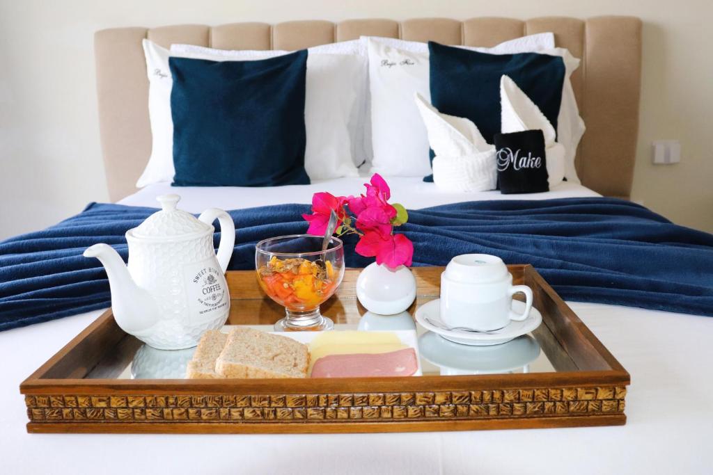 a tray with a tea set on top of a bed at Pousada Loft vista da serra in Serra de São Bento