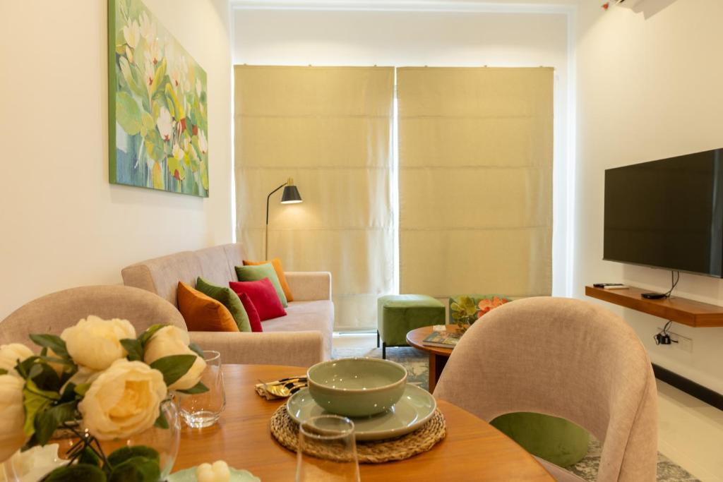 Una sala de estar con una mesa y sillas y un televisor. en Trizen OceanView, en Colombo