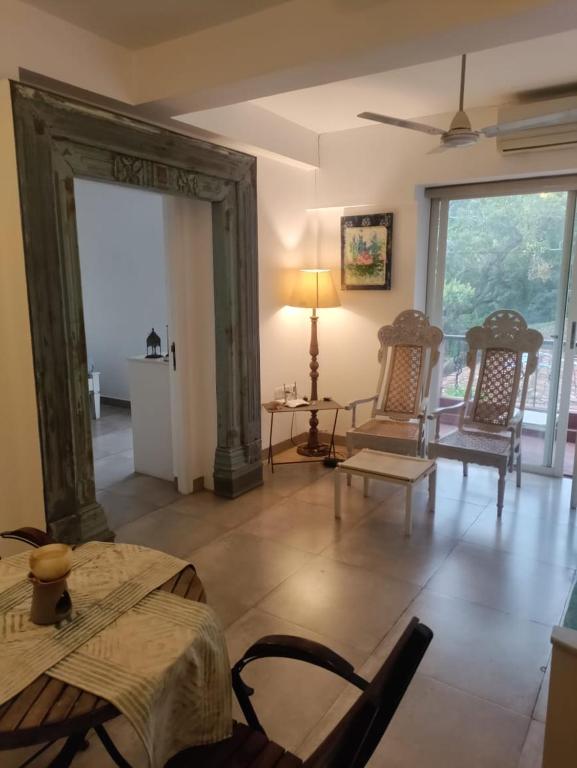 a living room with chairs and tables and a large doorway at AquaVista Calangute in Calangute