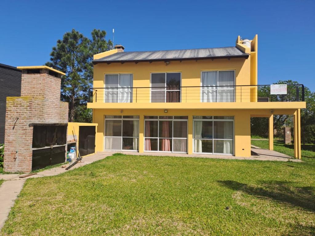 a yellow house with a yard in front of it at La casa del lago in Oliveros