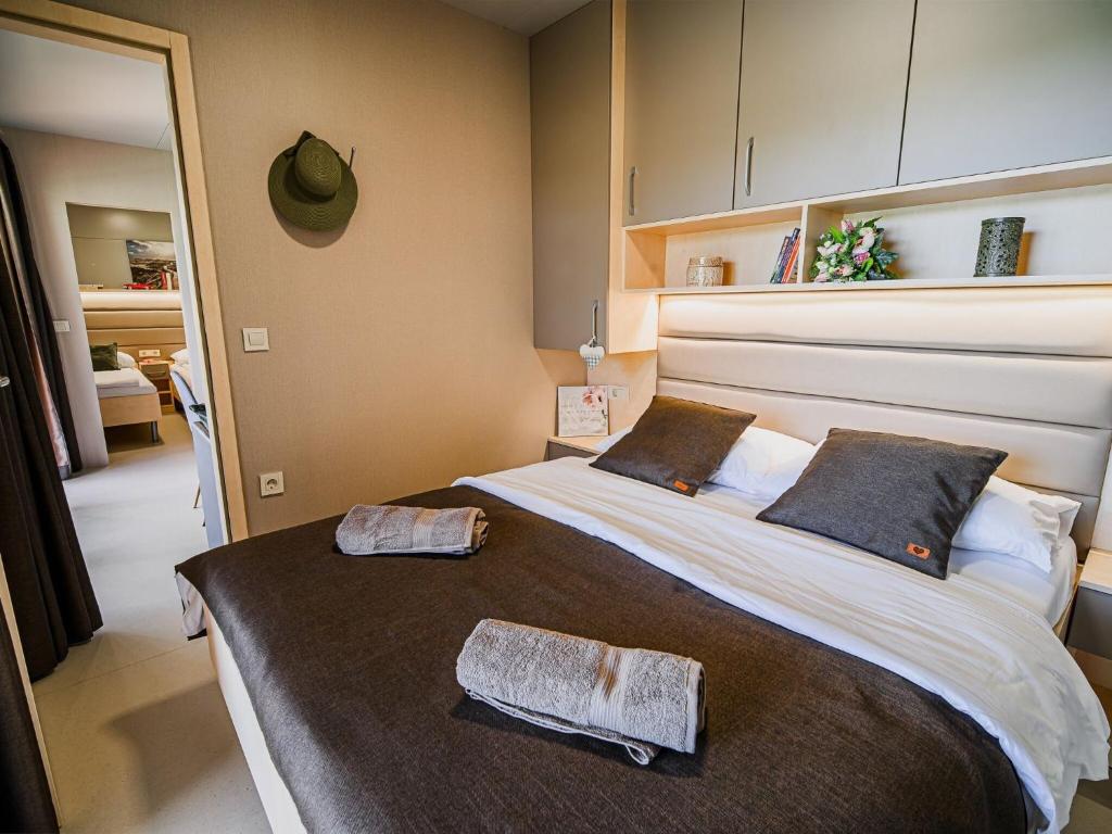 une chambre avec un grand lit avec deux serviettes dessus dans l'établissement Three Bedroom Mobile Home, à Mostec
