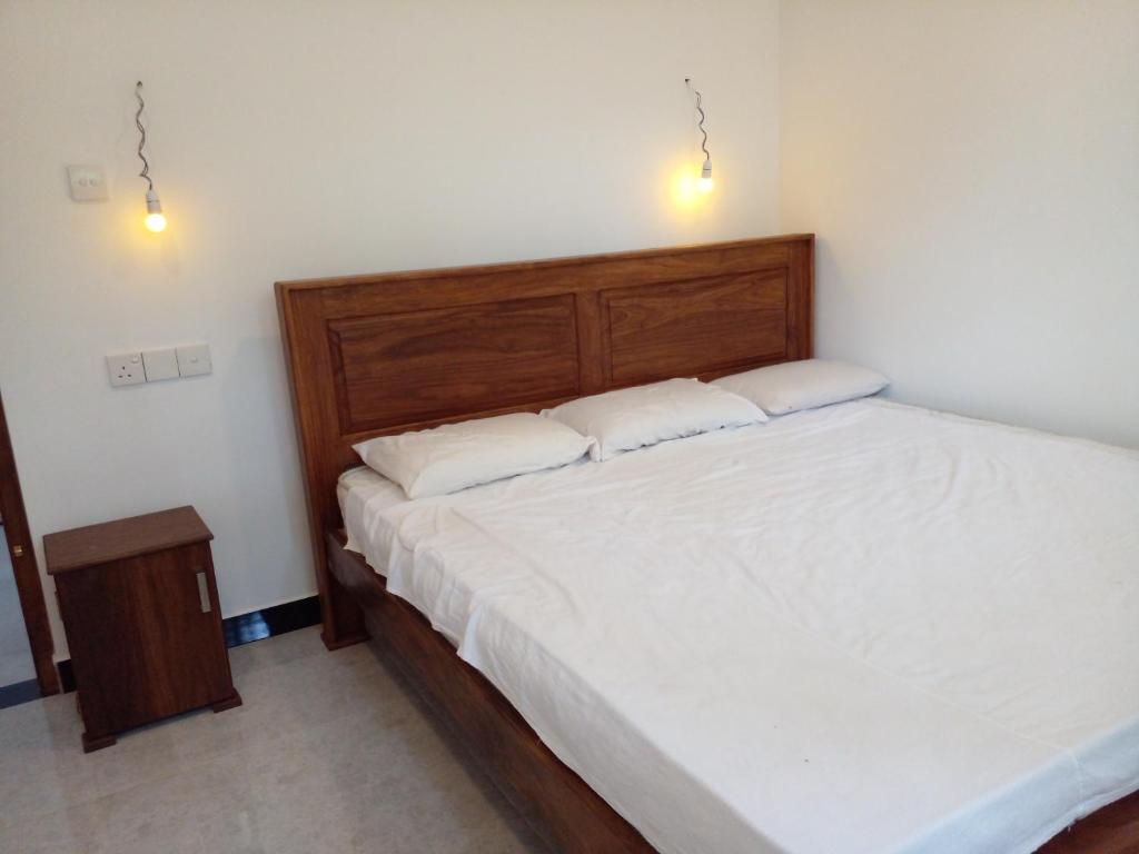 une chambre avec un lit avec deux oreillers blancs dans l'établissement Happy villa, à Weligama