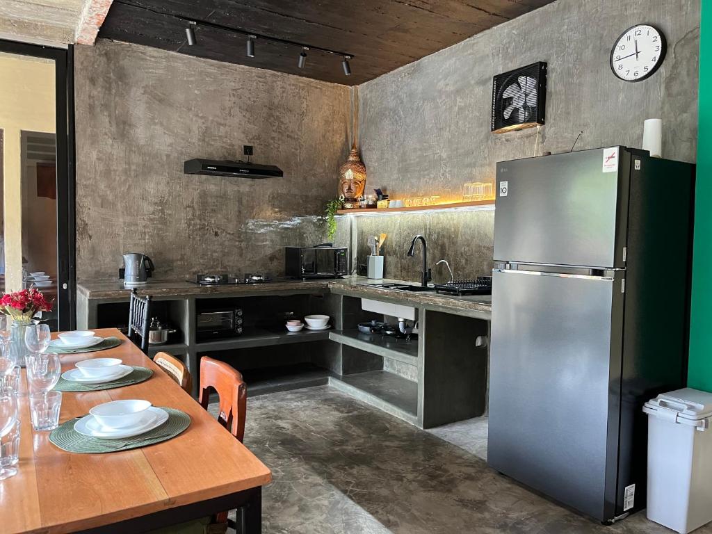 une cuisine avec une table en bois et un réfrigérateur dans l'établissement Authentic Nusa Dua home, 4BR, Renovated 2025, à Nusa Dua