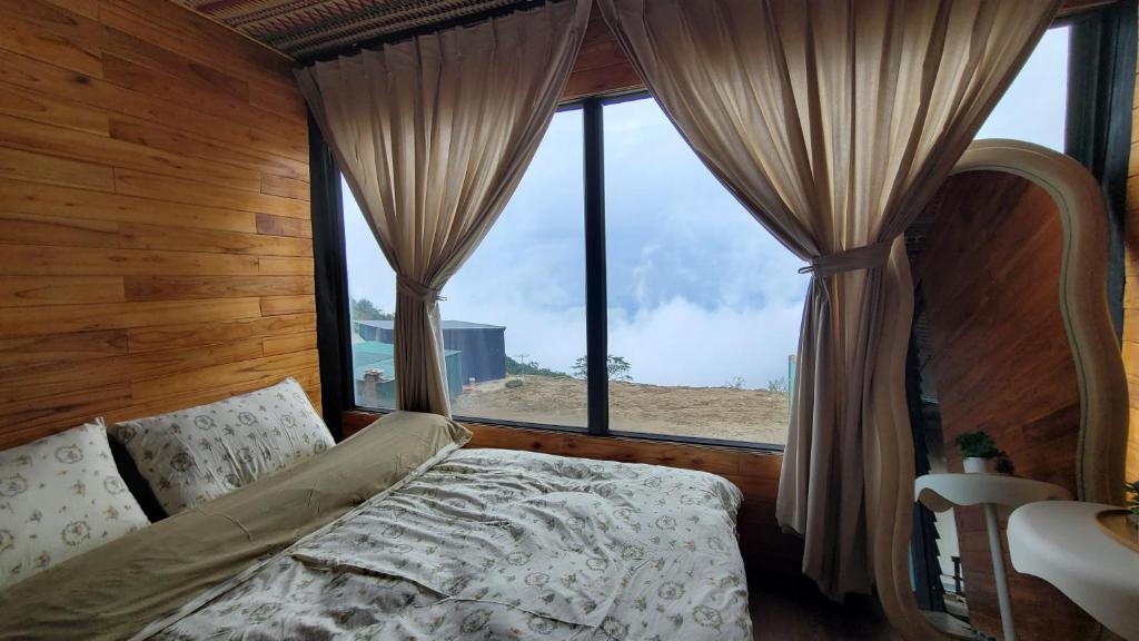 a bedroom with a bed and a large window at Chà Homestay in Bắc Yên