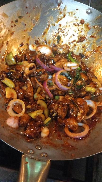 a pan full of food with meat and onions at Raaju fisherman life resort in Walliwala East