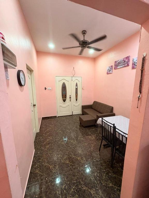 a living room with a couch and a ceiling fan at Saaidah Homestay in Pendang