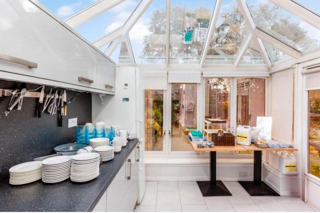 uma cozinha com teto de vidro com pratos em uma bancada em West Coates Mansion em Edinburgo