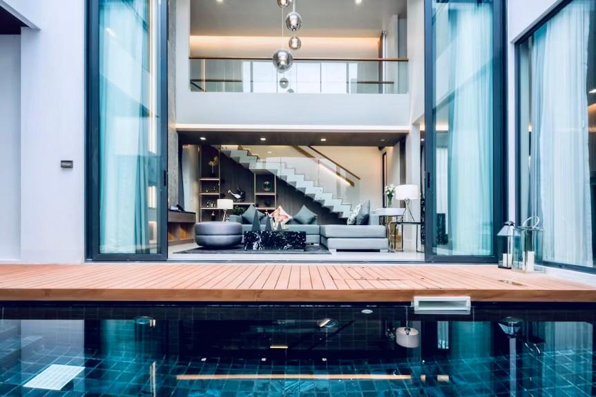 una casa con piscina e soggiorno di Mida Grande Resort 4BR Villa 8123 a Ban Lum Fuang