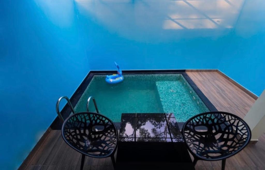 einen Pool mit zwei Stühlen und einem Brunnen in der Unterkunft Rendezvous Jungle Resort in Sultan Bathery