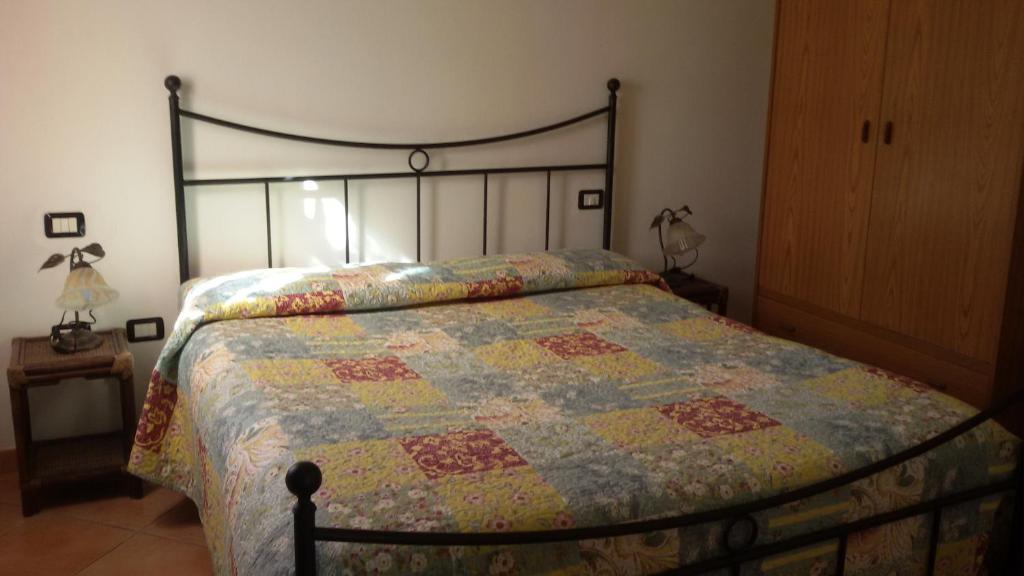 un letto con una trapunta in una camera da letto di Sardinia House Country a SantʼAnna Arresi