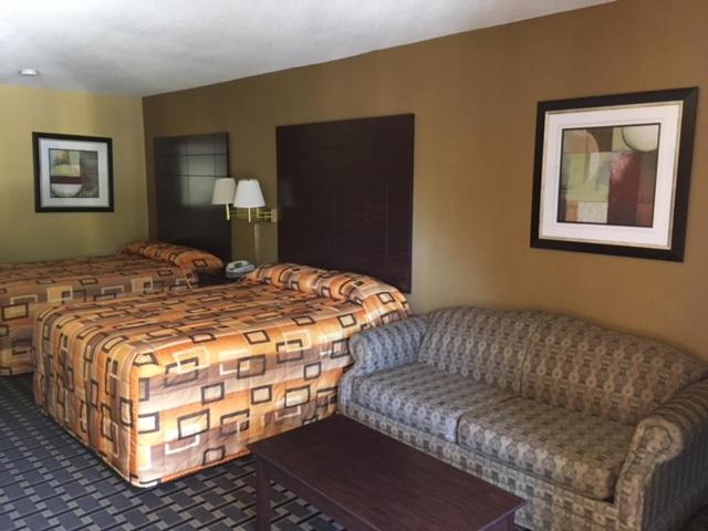 una camera d'albergo con letto e divano di Executive Inn and Suites Longview a Longview