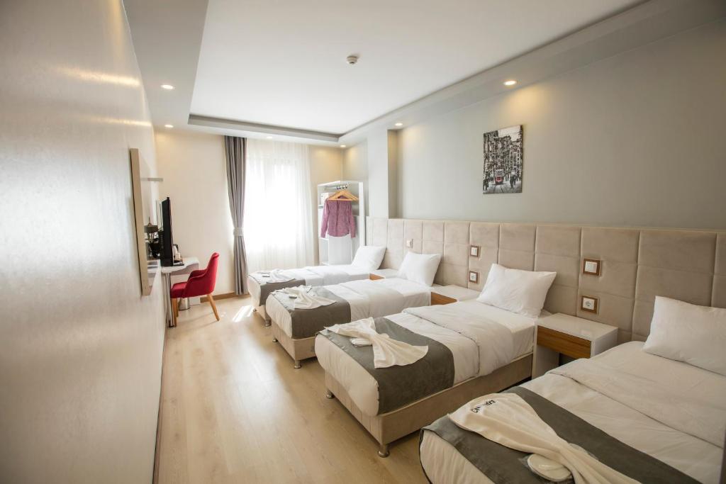 een hotelkamer met 2 bedden en een bureau bij Express İnci Hotel in Istanbul