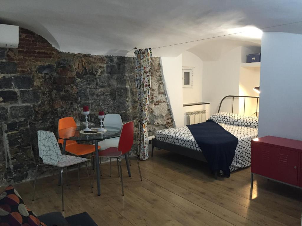 Cette chambre comprend un lit, une table et des chaises. dans l'établissement Le Grazie Maisons Genova, à Gênes