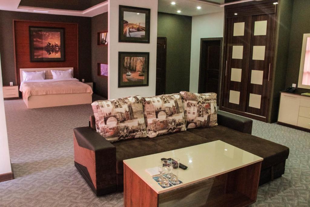 sala de estar con sofá y cama en Paradise Hotel, en Saryaghash