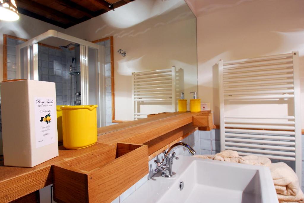 bagno con lavandino e specchio di Feronia - Le Dimore di Borgo Tessile a Orvieto