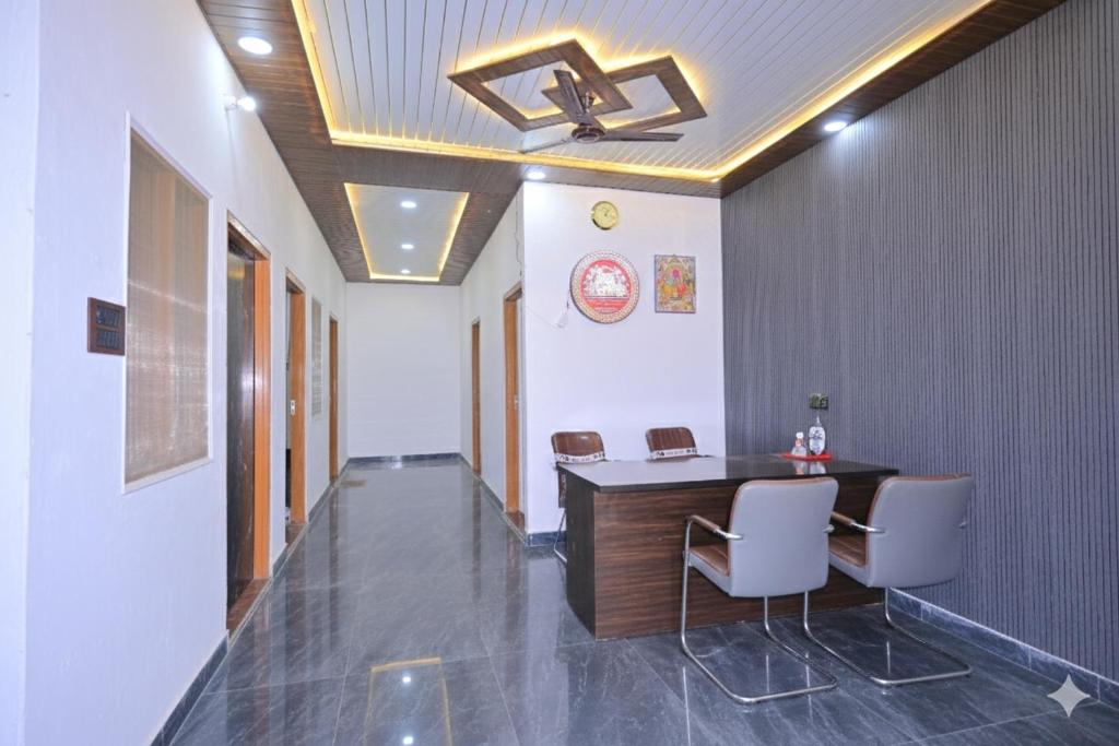 FaizābādMonishka Palace的走廊里的一间办公室，里面有一张桌子和几把椅子。